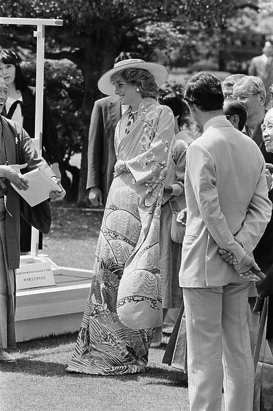 HRH Princess Diana, The Princess of Wales, is helped by city officials to wear a