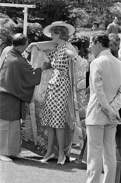 HRH Princess Diana, The Princess of Wales, is helped by city officials to wear a