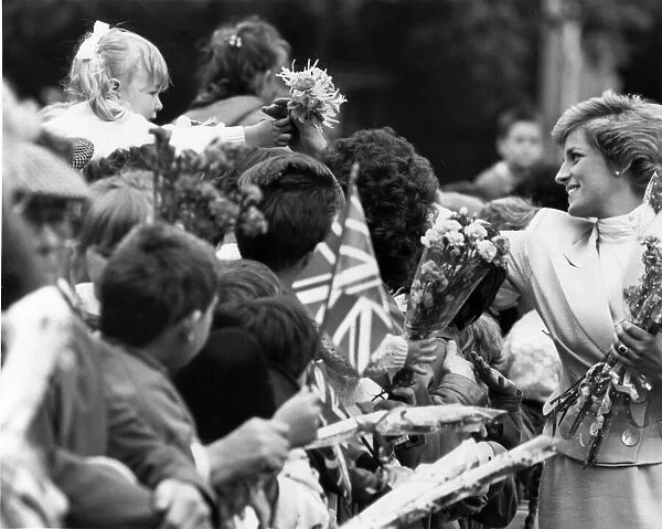 HRH Princess Diana, The Princess of Wales reaches out to take a bouquet from a little