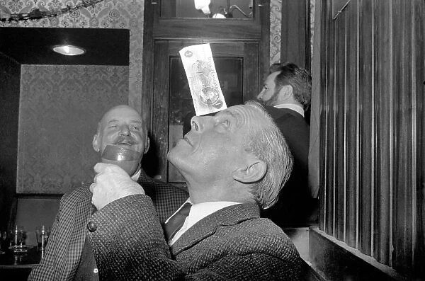 Humour  /  Unusual. John Mitchell balancing a pound note. February 1975 75-00662