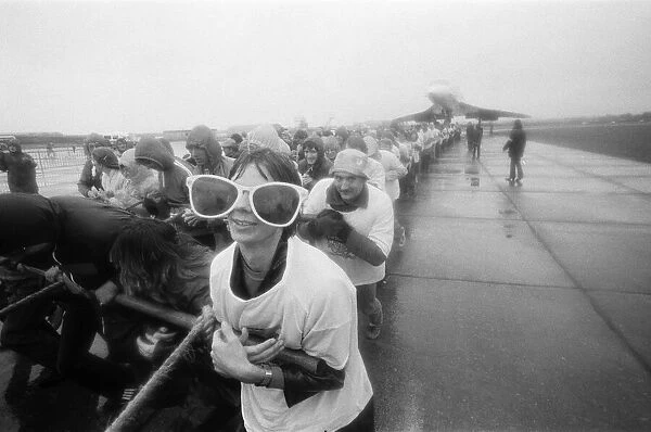 Hundreds of people were drenched by heavy rain as they pulled Concorde around an airfield