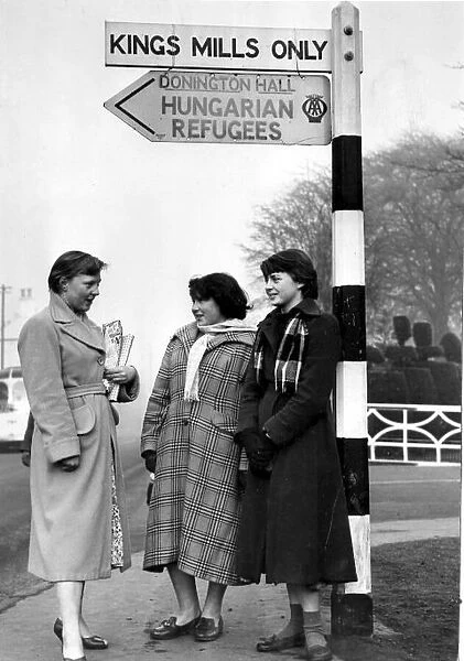 Hungarian Refugees Three girl guides stand at the sign post for Hungarian Refugees