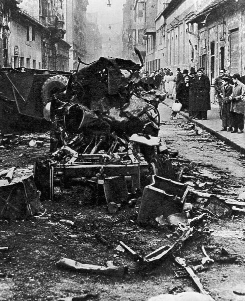 Hungarian Revolt 1956. Onlookers inspect the tangled wreckage of an unidentified vehicle