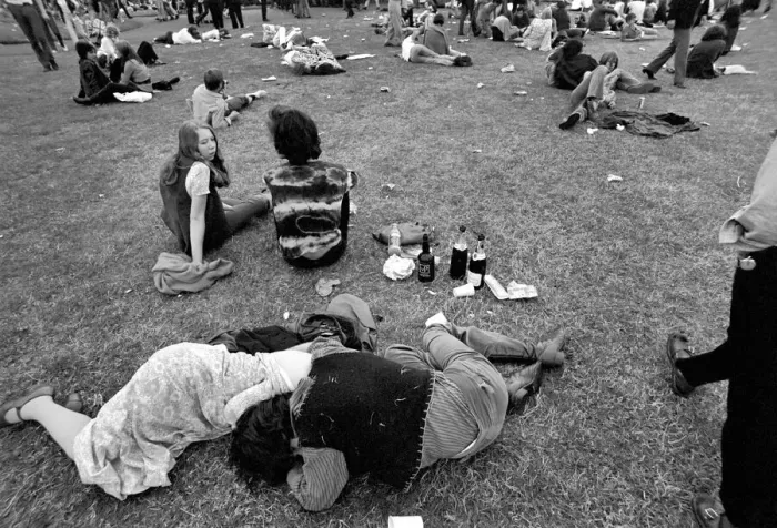 Framed Print : Hyde Park Pop Festival. Couple oblivious to the surroundings embrace by empty wine