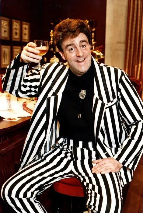 Framed Print : Iain McColl actor in black and white striped suit raising glass whisky toast STV Hogmanay