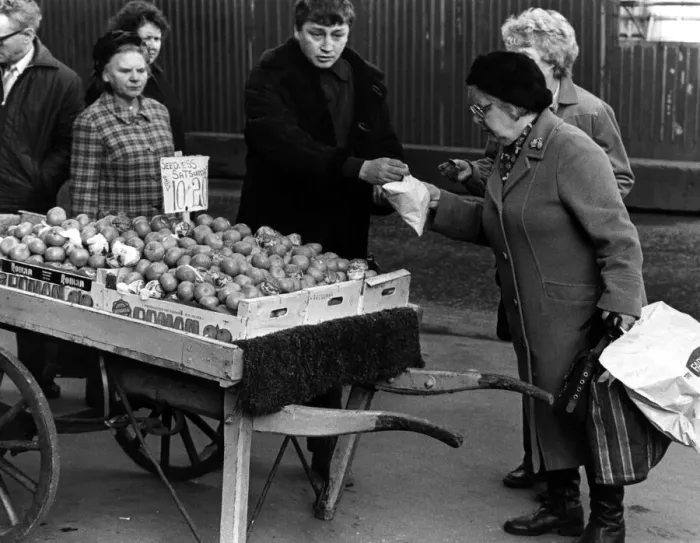 Framed Print : Illegal street trader tommy Quinn makes a sale before having to move on 31st January 1981 Framed Print : Illegal street trader tommy Quinn makes a sale before having to move on 31st January 1981