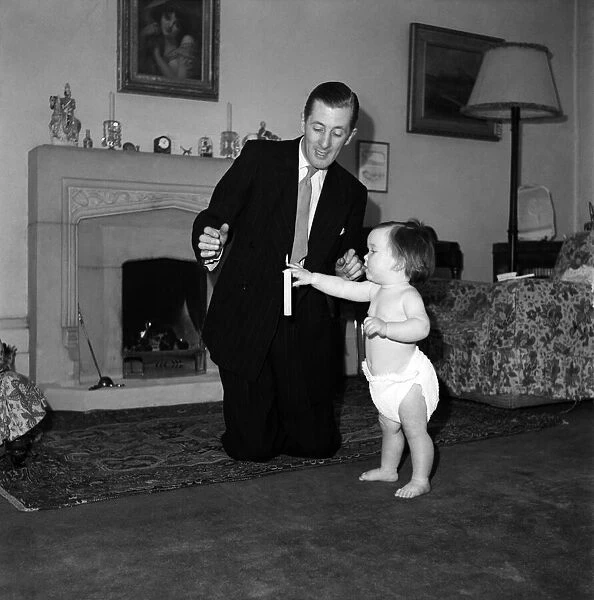 Illusionist Jon Evans seen here with a baby March 1952 C1112