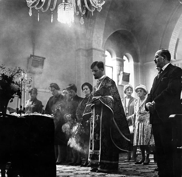 Incense burns as Father Spiros Desylas intones during a service at the Greek Orthodox