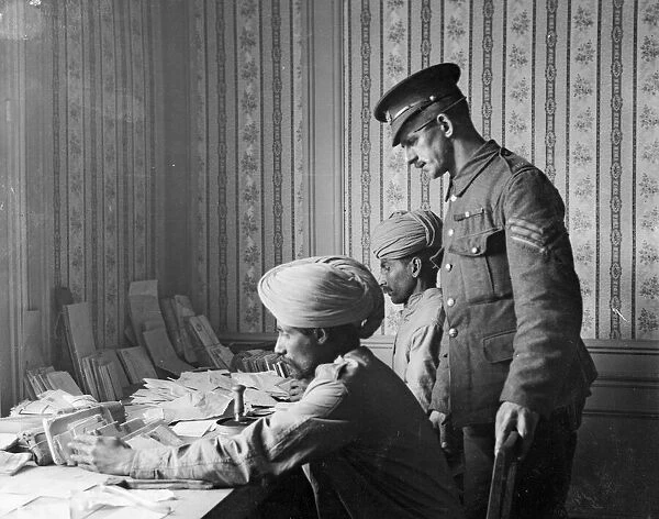 Indian and British soldiers at work censoring letters in a military post office in France