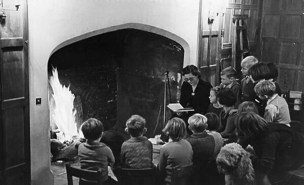 By the inglenook fire of an old English mansion, these happy evacuee children from a