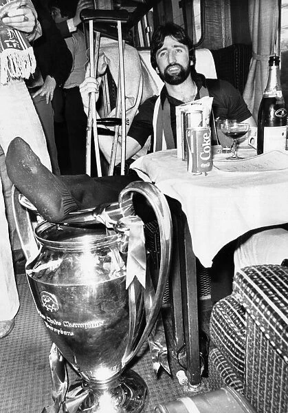 Injured Liverpool footballer David Johnson rests his leg on the European Cup trophy