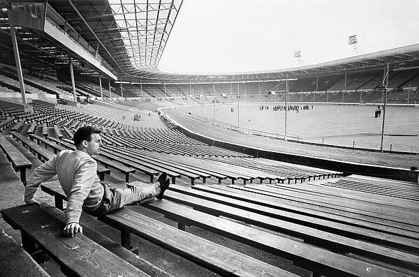 Injured Liverpool footballer Gordon Milne looks out over Wembley Stadium as his teammates