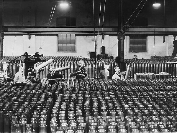 Inspectors check the quality of shells for naval guns in a munitions factory during WW2