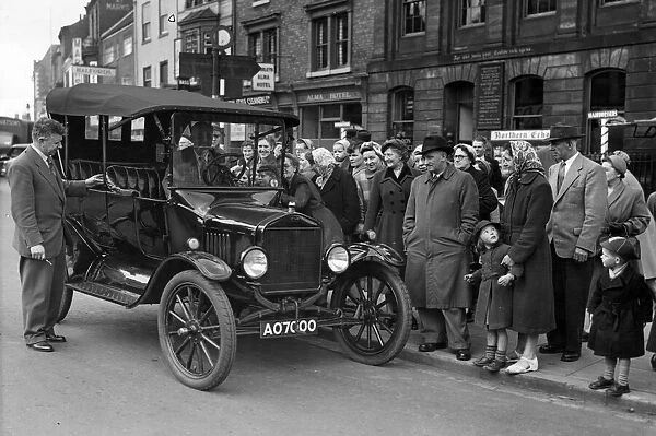 An interested crowd gathers round this T Model Ford car as it pulls up in Stockton High