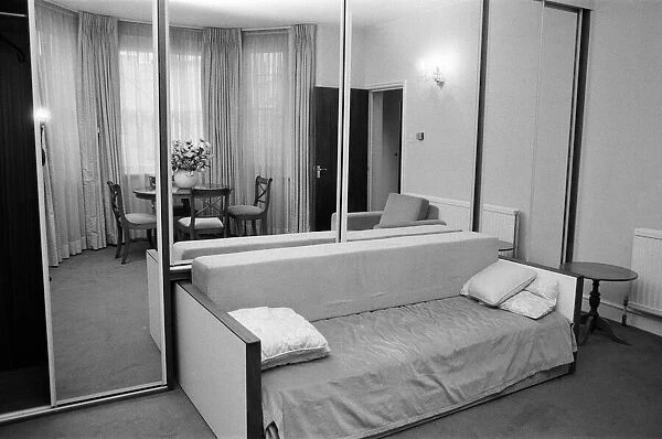 Interior view of a flat, showing the living room area, mirrored wardrobe and sofa bed