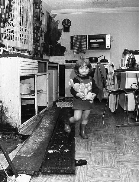 Interior view of a London terraced house showing a child in the kitchen March 1983
