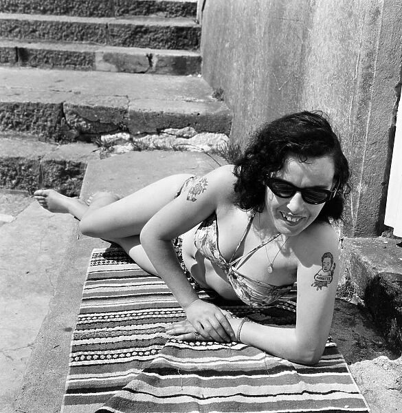 Irene Redpath shows of her tattoos as she relaxes on the beach. 11th June 1962