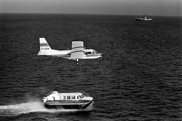 Islander aircraft flies over Cushion Craft Hovercraft, off the Isle of Wight