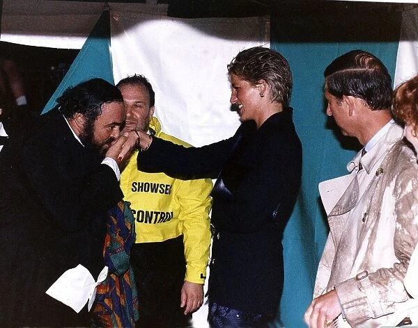 Italian opera singer Luciano Pavarotti kisses the hand of Princess Diana as Prince