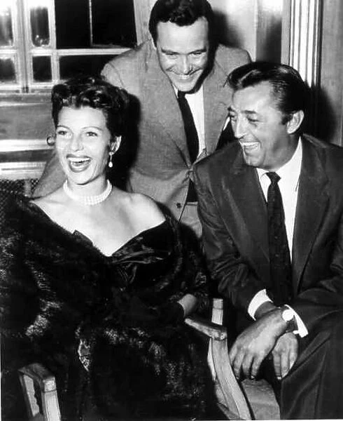 Jack Lemmon with Rita Hayworth and Robert Mitchum, laughing as they sit posing for