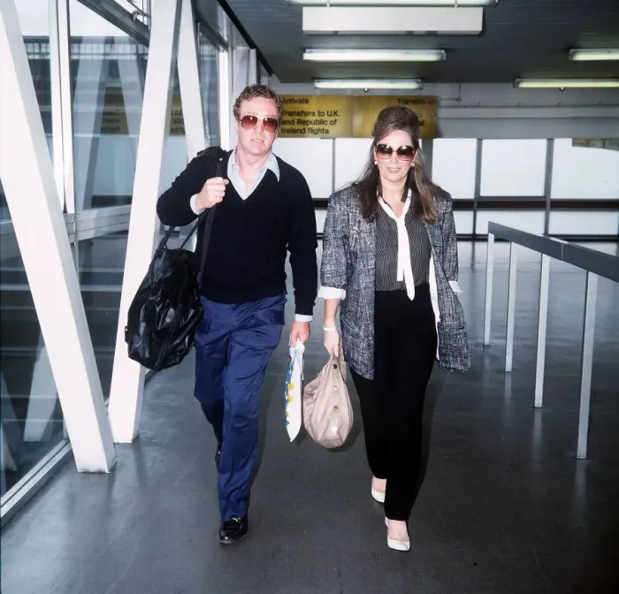 Framed Print : Jackie Collins Writer walking through Heathrow airport with Michael Caine