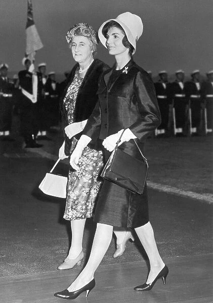 Jacqueline Onassis Kennedy walking across the tarmac with Mrs Dorothy MacMillan having