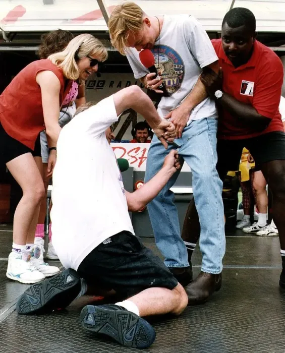 Framed Print : Jason Donovan Balloch Park Radio 1 roadshow being held from behind by black man while Framed Print : Jason Donovan Balloch Park Radio 1 roadshow being held from behind by black man while