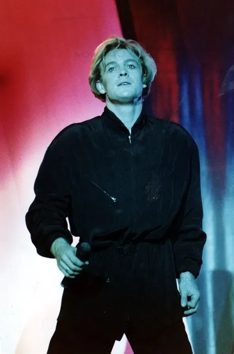 Framed Print : Jason Donovan on stage in Edinburgh face lit green blue black shirt trousers holding