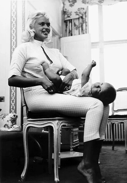 Jayne Mansfield changes the nappy of her son Mickey July 1959