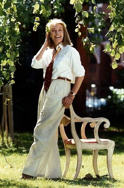 Jean Marsh actress standing in garden resting on back of chair, September 1989