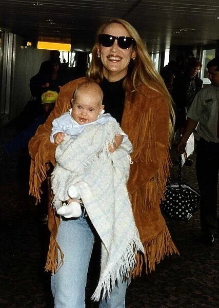 Jerry Hall Supermodel and Actress walking through Heathrow Airport carrying her daughter