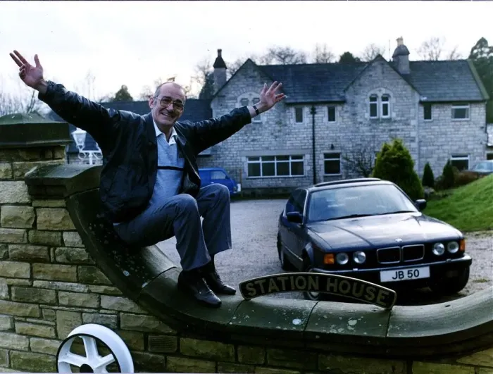 Framed Print : Jim Bowen comedian / TV presenter sitting on his garden wall with arms outstretched Framed Print : Jim Bowen comedian / TV presenter sitting on his garden wall with arms outstretched