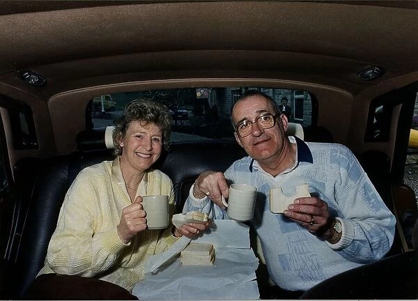 Jim Bowen TV Presenter Bullseye sitting in the back of a Rolls Royce with his ife Phyllis