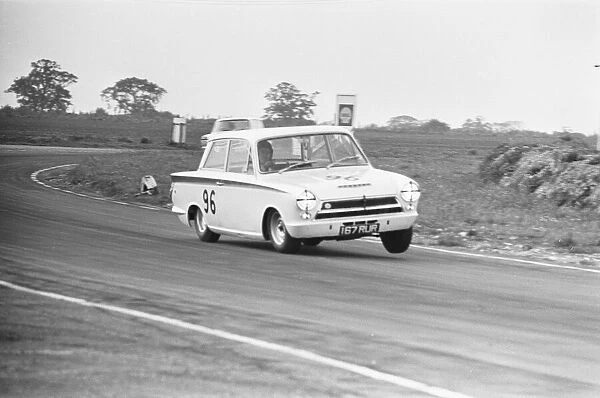 Jim Clark in the Team Lotus Cortina seen here lifting a wheel through the esses at