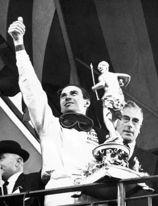 Framed Print : Jim Clark waves to the crowd as he holds the trophy presented to him by Earl Mountbatten