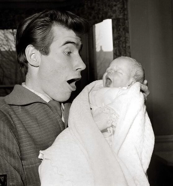 Jim Dale holds his new born baby girl Jane Belinda after her birth at a nursing home in