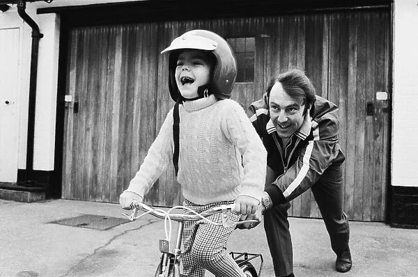 Jimmy Greaves pushing his 4-year old son Andrew, wearing his fathers crash helmet