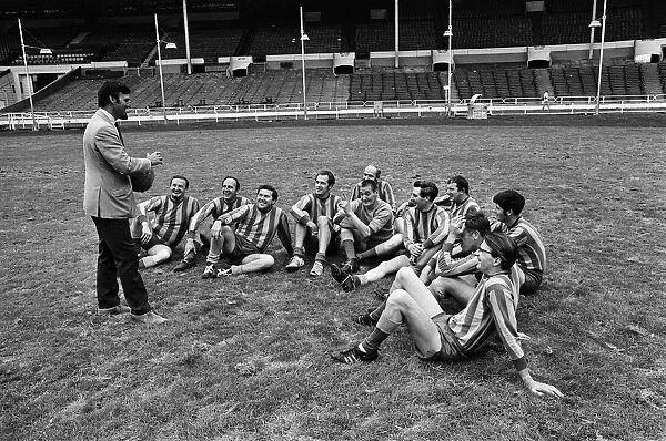 Jimmy Hill pictured talking to a football team. Television presenter Dickie Davies is