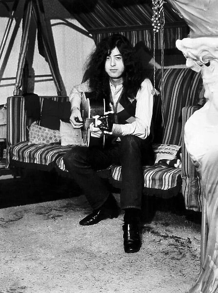 Jimmy Page of Led Zeppelin at home with his guitar