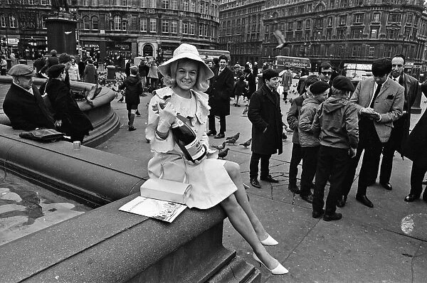 Jimmy Tarbuck signs autographs in Trafalgar Square, London while Miss Liverpool Maureen