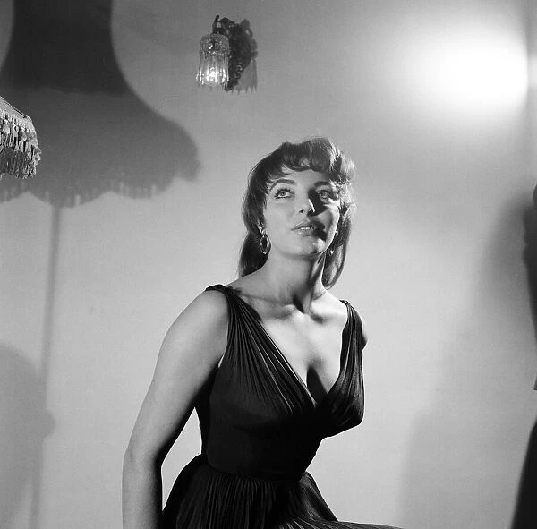 Joan Collins, actress, aged 22, pictured wearing black silk cocktail dress
