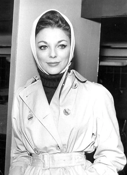 Joan Collins at London Airport wearing macintosh coat and headscarf - December 1961