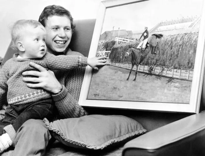 Framed Print : Jockey Brian Fletcher pictured showing his son Andrew a painting of Red Rum landing over