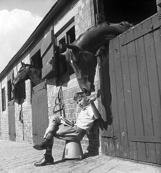 Jockey Lester Piggott aged twelve sitting by the stables, August 1948