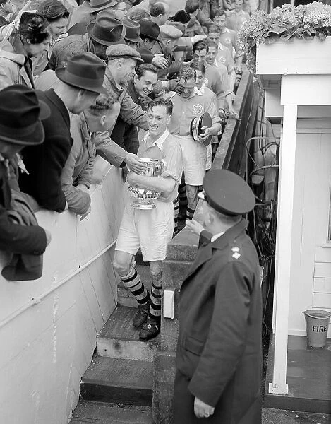 Joe Mercer walks down from the Royal Box at Wembley after collecting the FA Cup for