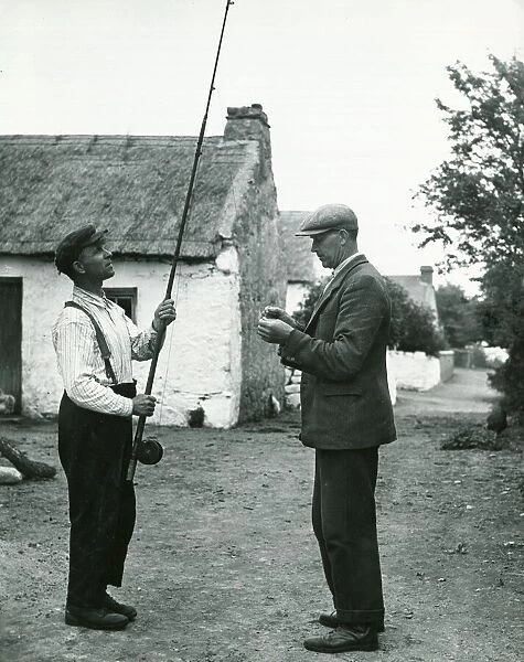 John Barrett and boatman Dick Burke enjoy a 'tall: fishing story together circa 1947