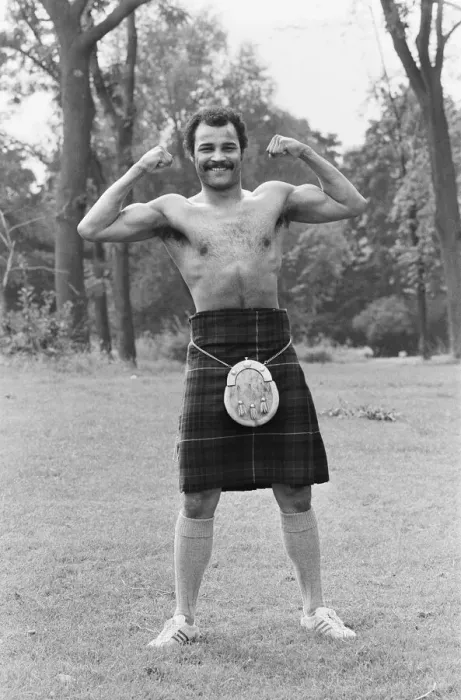 Framed Print : John Conteh gets the Scottish flavour on Parliament Hill Fields today watched by curious