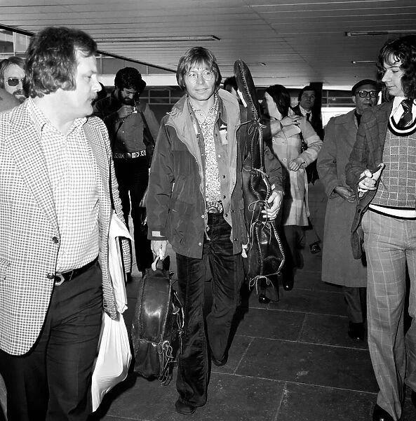John Denver: U. S. singer seen here at London Airport with his guitar. April 1976
