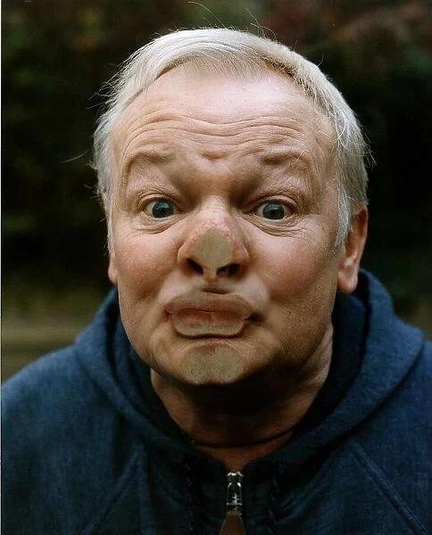 John Inman Comedy Actor presses his face up against a pane of glass to hide his identity