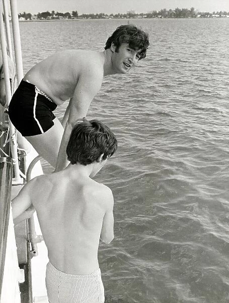 John Lennon and George Harrison of the Pop group The Beatles go for a swim during their